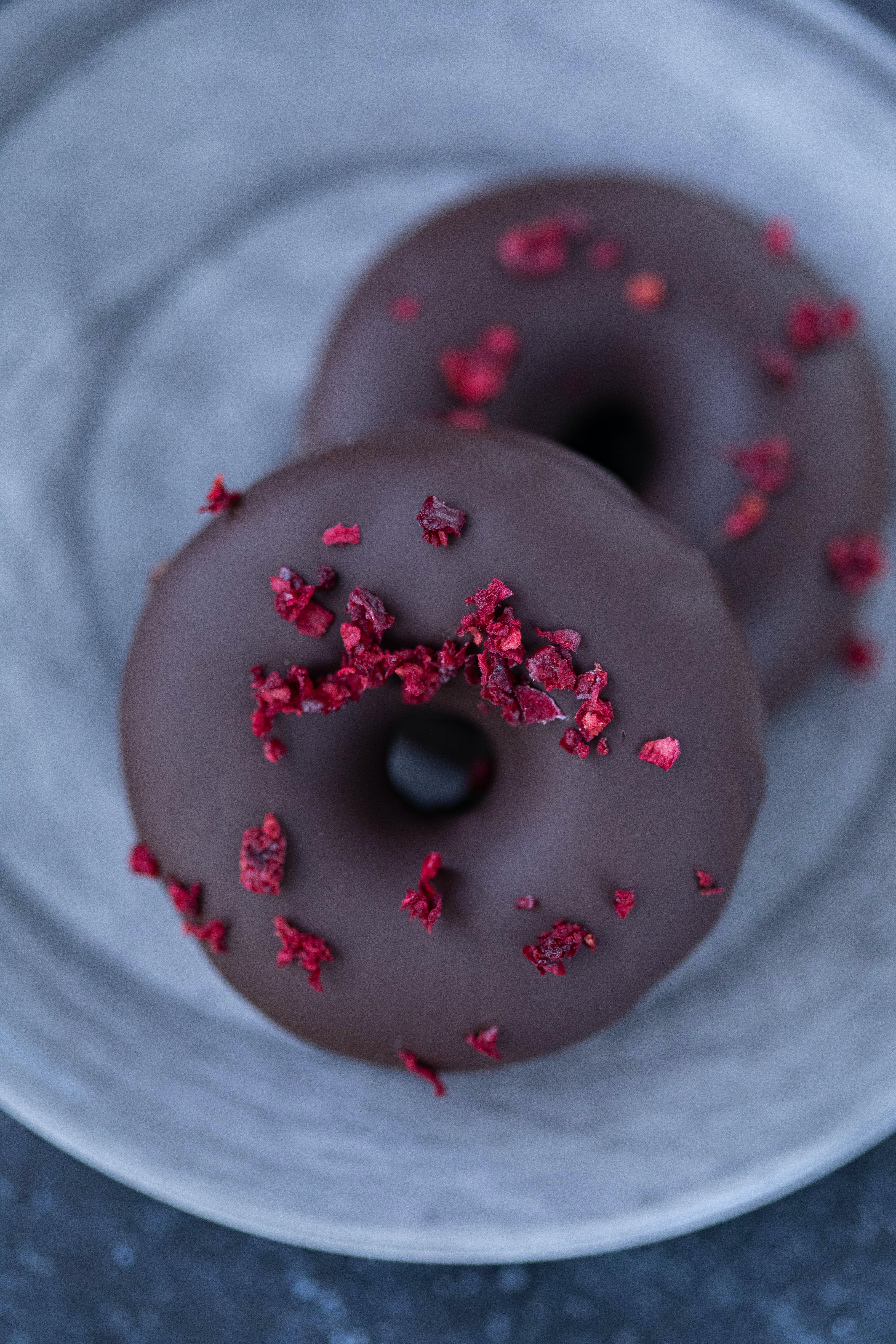 chocolate donut with rose petals sprinkled on top