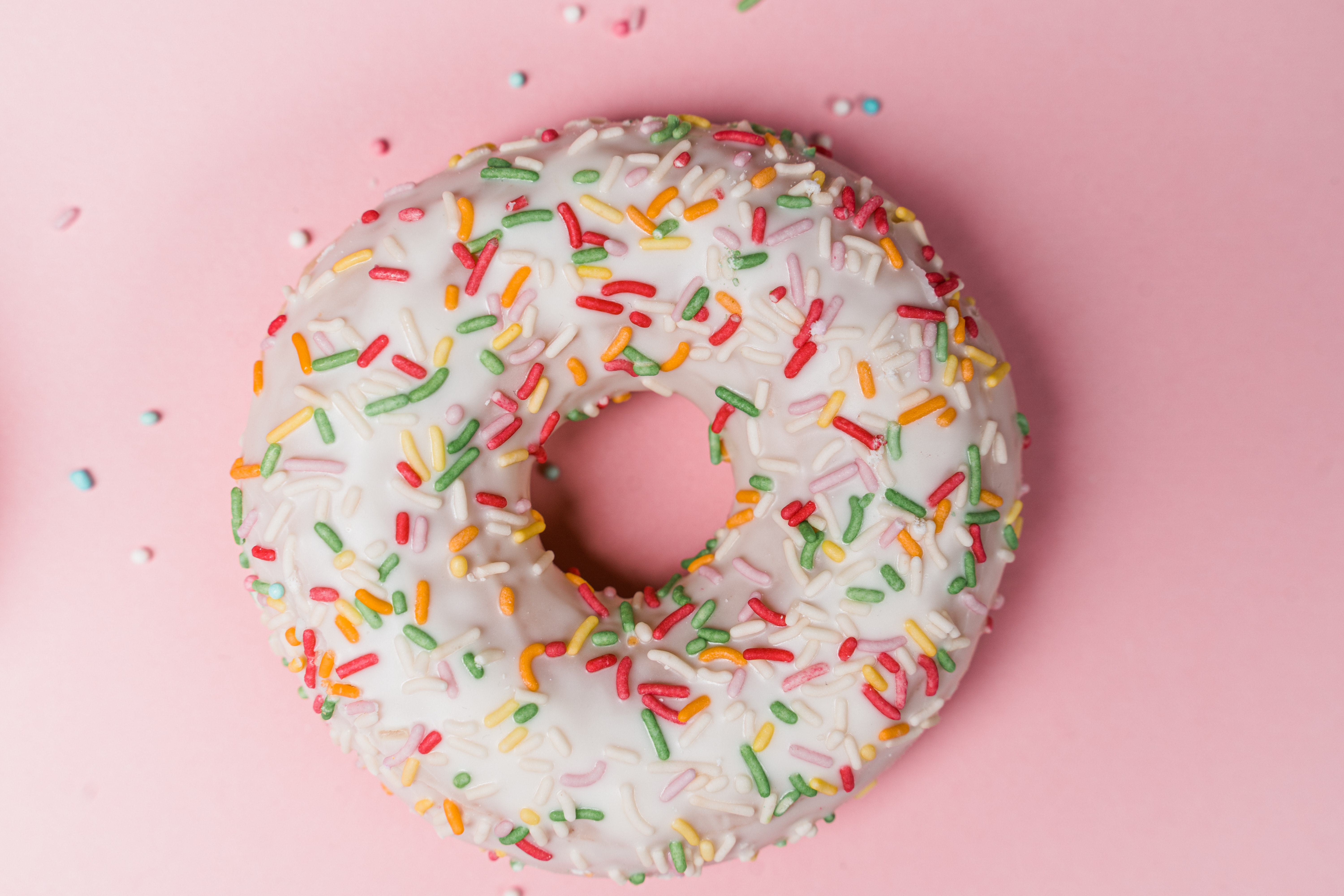 white chocolate donut with colourful sprinkles on top